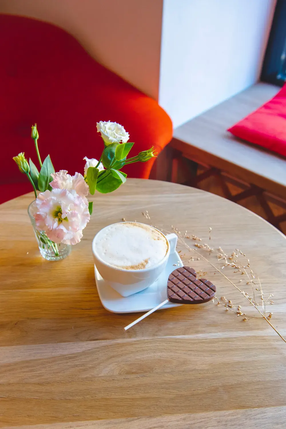 Acadea de ciocolată cu lapte Choco Toni și o cafea, pe o măsuță din ciocolaterie