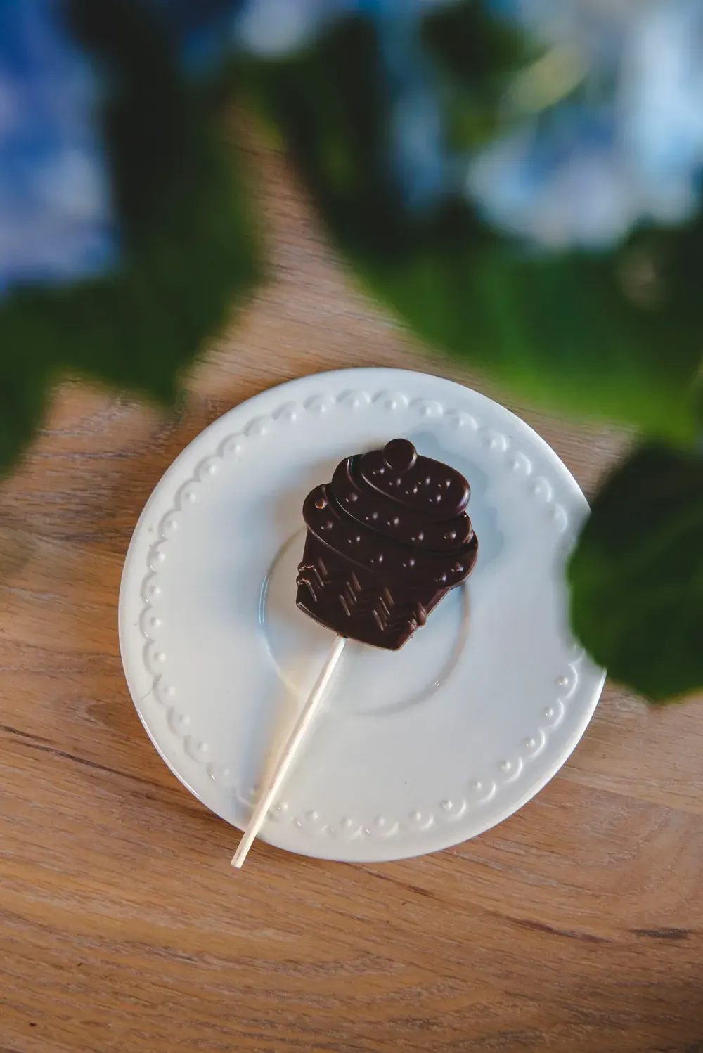 Acadea de ciocolată neagră Choco Toni în formă de brioșă, pe o farfurioară albă