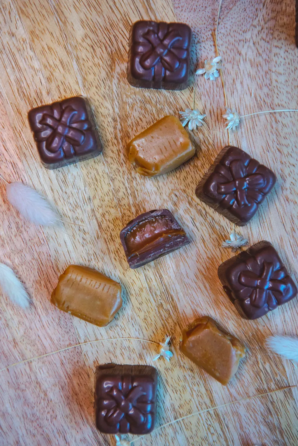 Bomboane de ciocolată cu lapte și caramel Choco Toni, întregi și tăiate, pe lemn