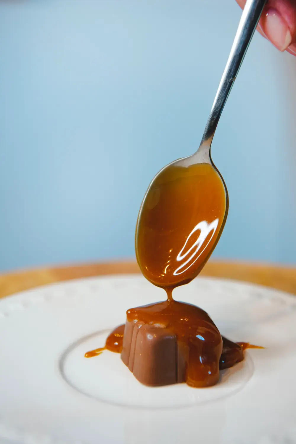 Caramel turnat cu lingurița peste o bomboană de ciocolată cu lapte Choco Toni