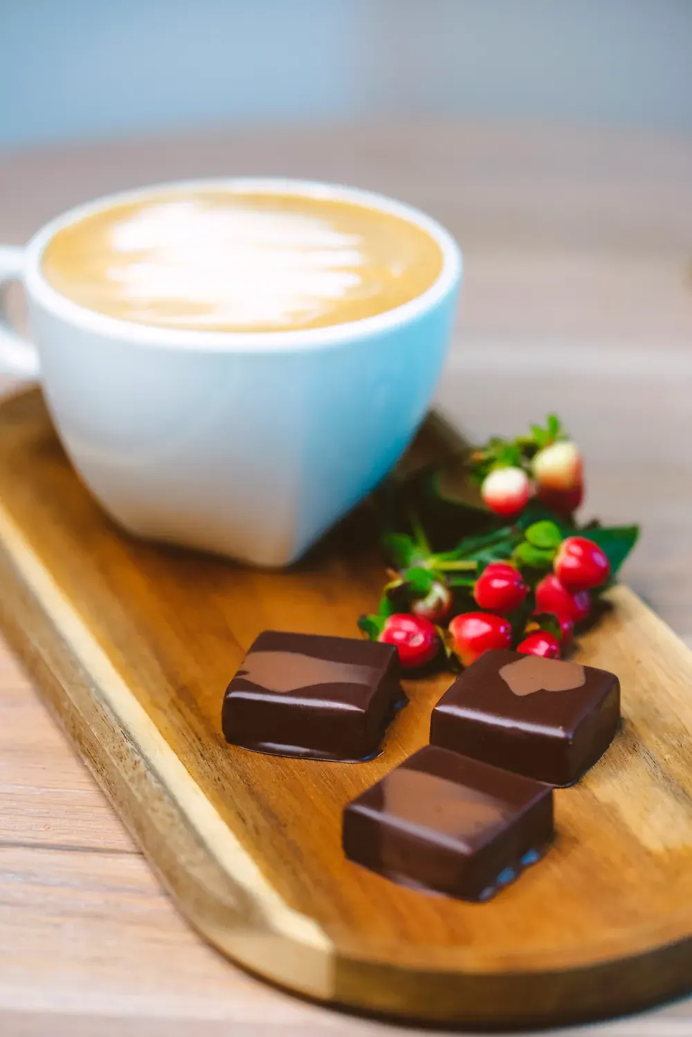 Bomboane de ciocolată neagră cu condimente de turtă dulce Choco Toni pe un platou, lângă o cafea