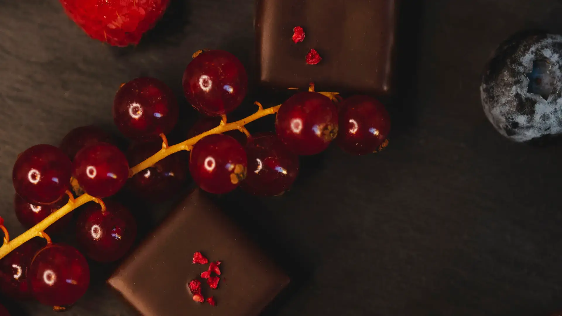 Bomboane de ciocolată Choco Toni cu coacăze roșii, pe fundal închis