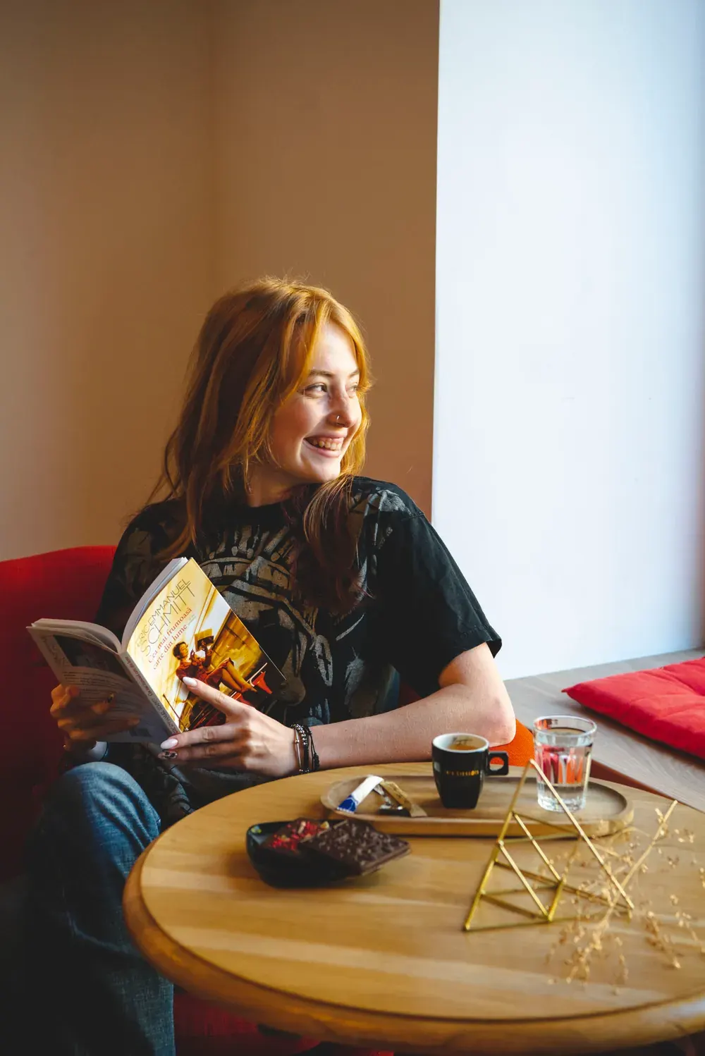 Tânără care citește la o cafea, cu ciocolată Choco Toni pe masă