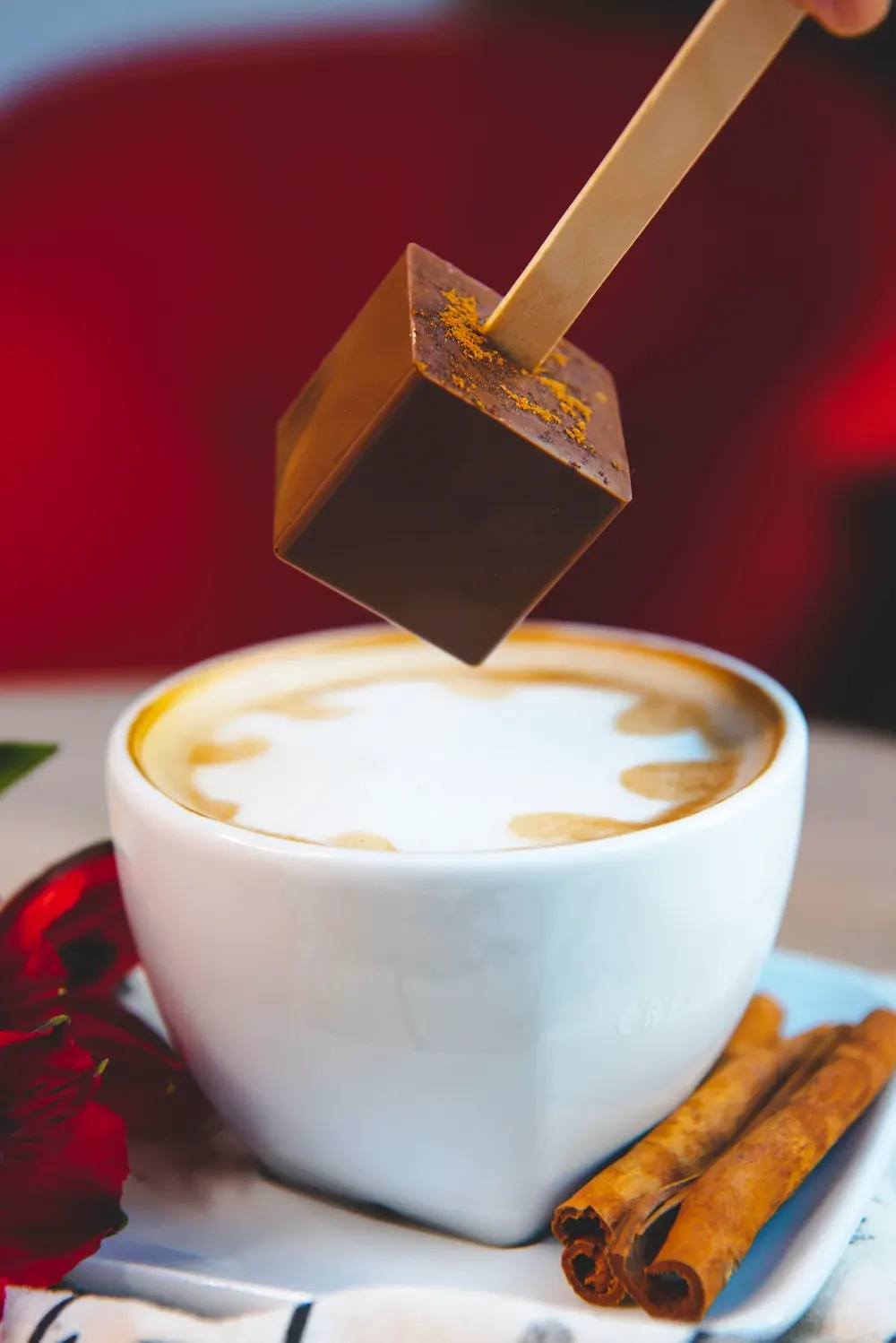 Ciocolată caldă cu lapte și scorțișoară Choco Toni pe băț, deasupra unui cappuccino