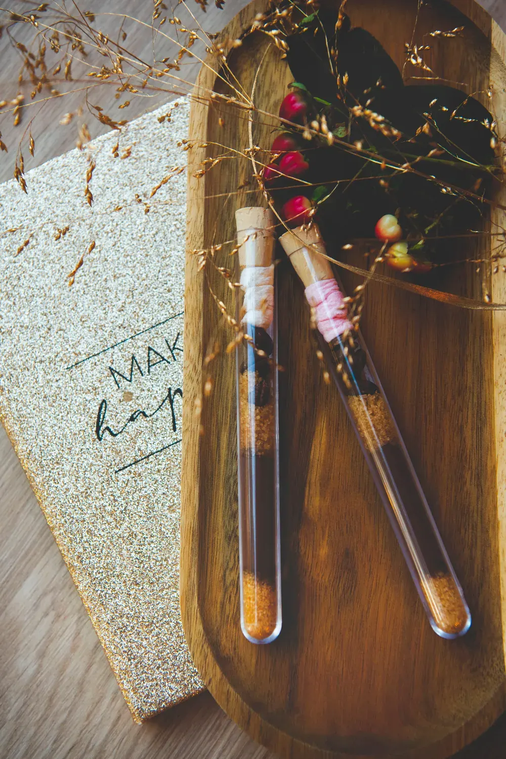 Două eprubete cu ciocolată caldă Choco Toni pe un platou de lemn, lângă o felicitare