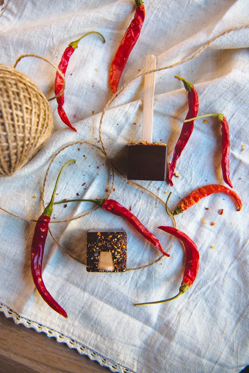 Ciocolată caldă neagră cu chilli Choco Toni pe băț, printre ardei iuți uscați