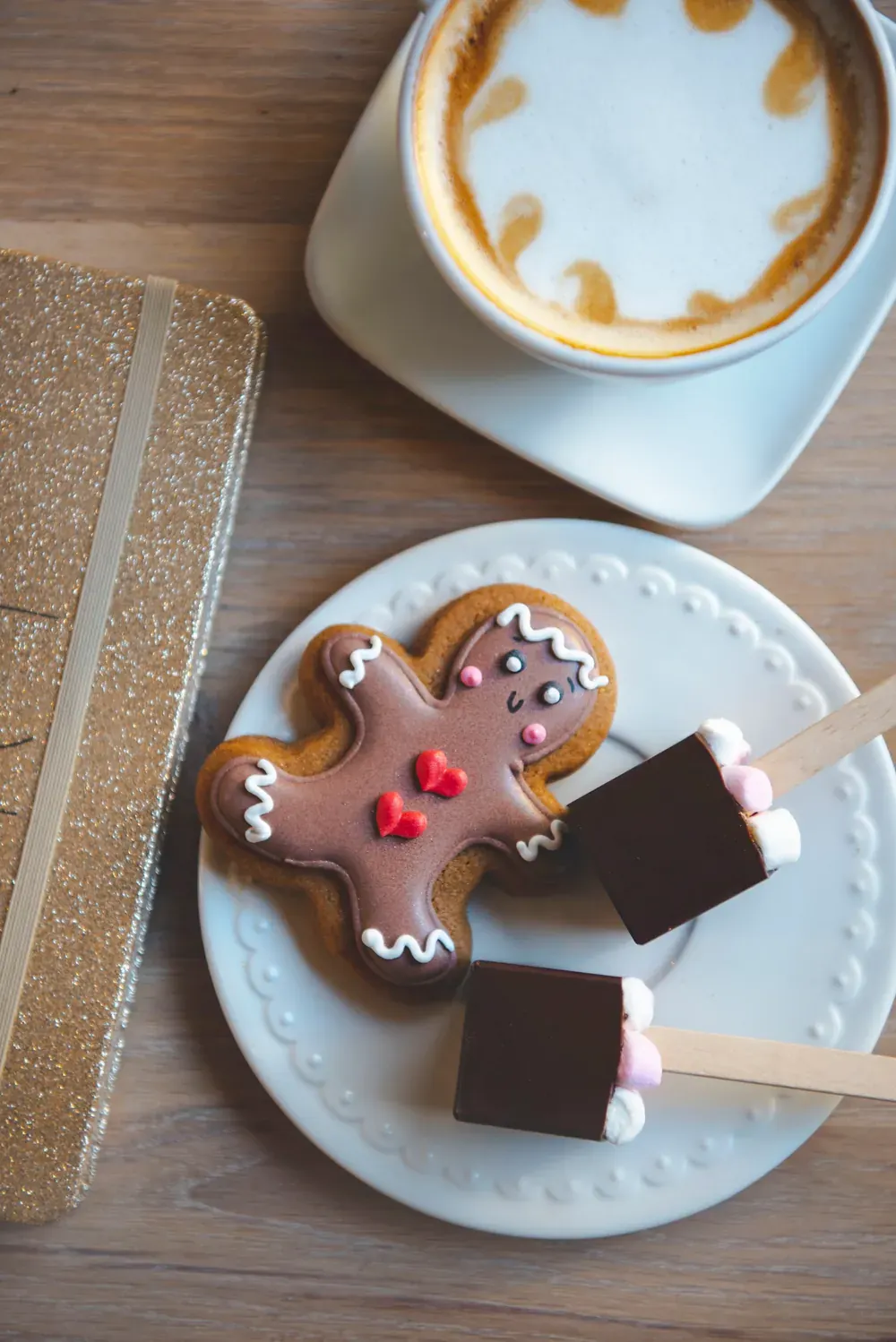 Ciocolată caldă cu minibezele și condimente de turtă dulce Choco Toni, lângă un cappuccino