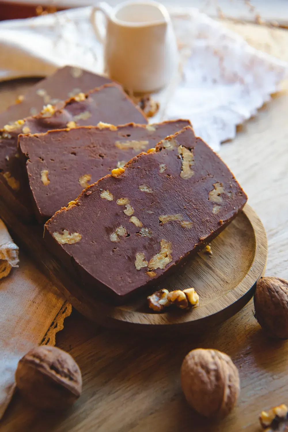 Fudge de ciocolată cu lapte și nuci Choco Toni pe un platou, lângă o cană cu lapte