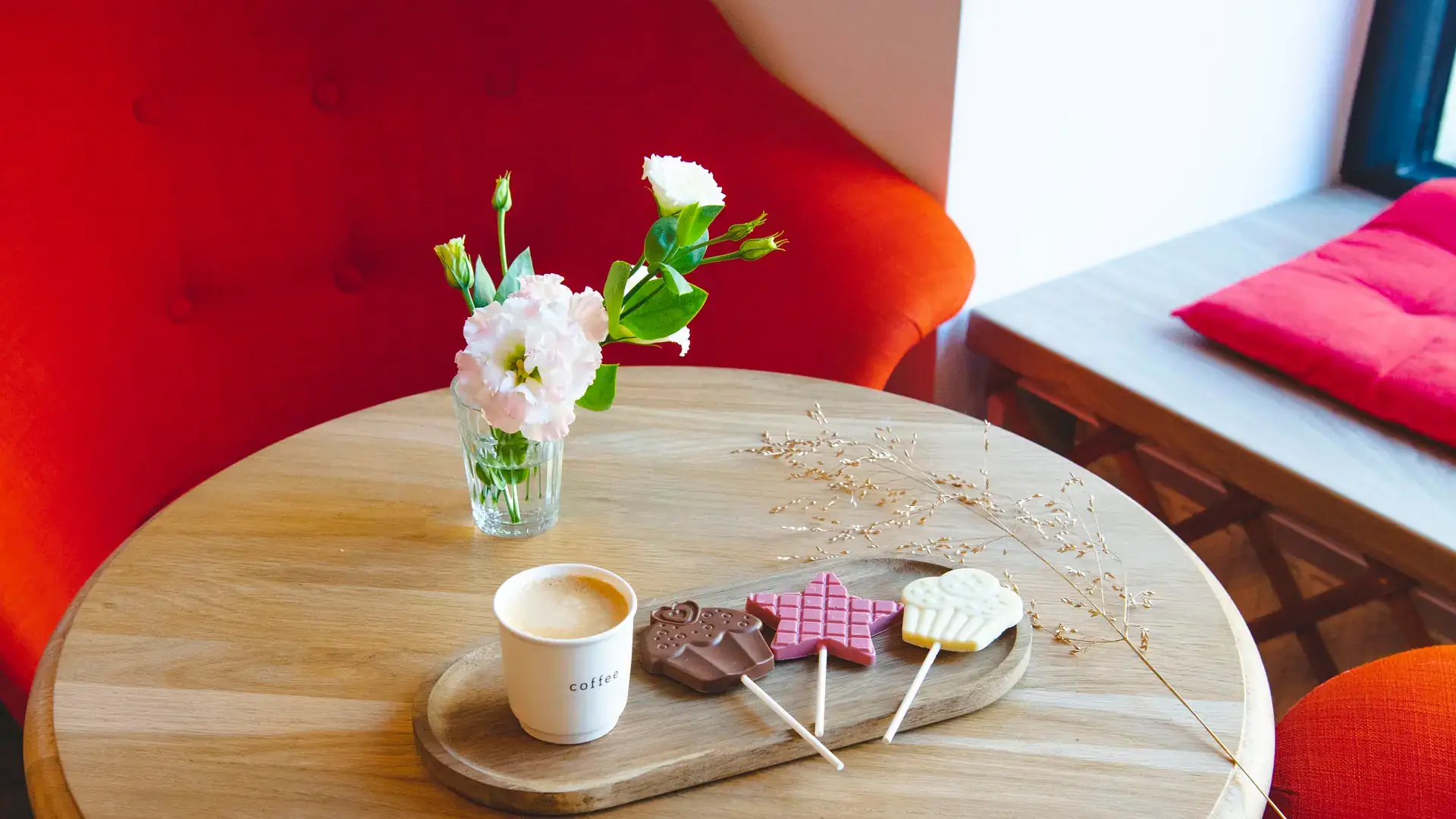 Măsuță în ciocolateria Choco Toni, cu cafea, acadele de ciocolată și flori