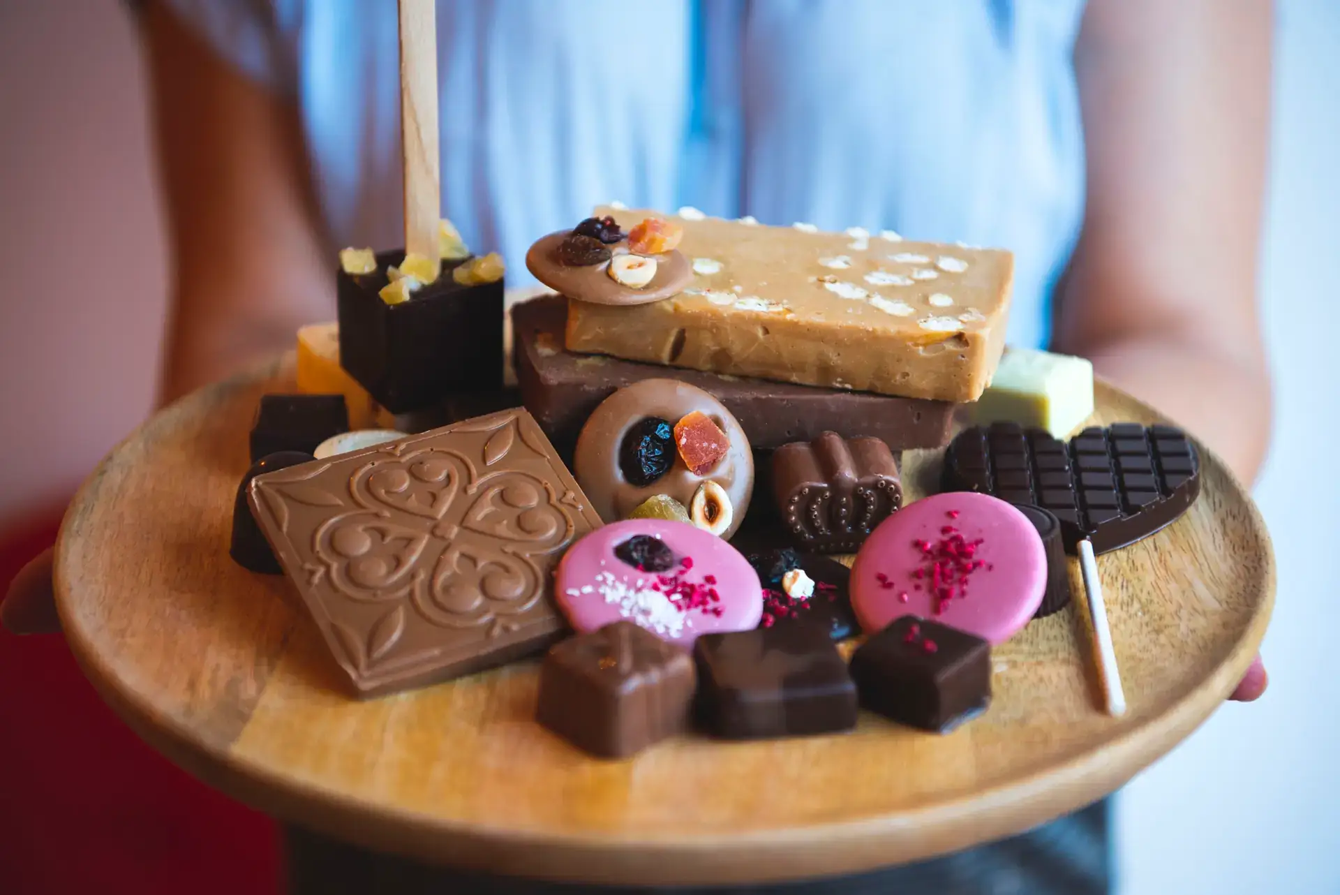 Platou cu bomboane, tablete și acadele Choco Toni, ținut în mâini