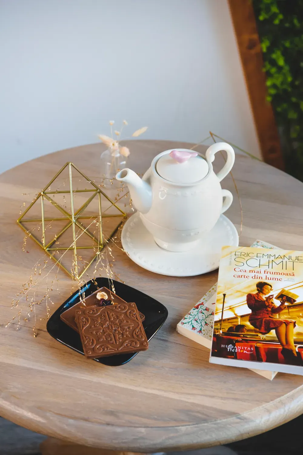 Tabletă de ciocolată cu lapte 33,6% Choco Toni pe o măsuță, lângă un ceainic alb