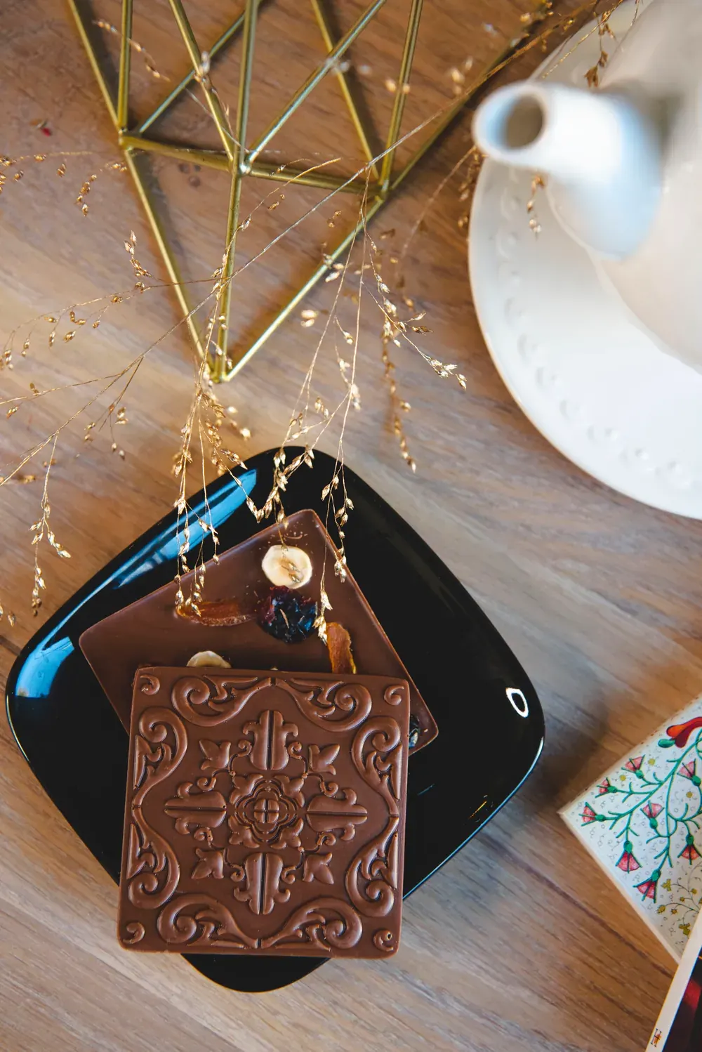 Tabletă de ciocolată cu lapte Choco Toni cu model în relief, pe o farfurie neagră