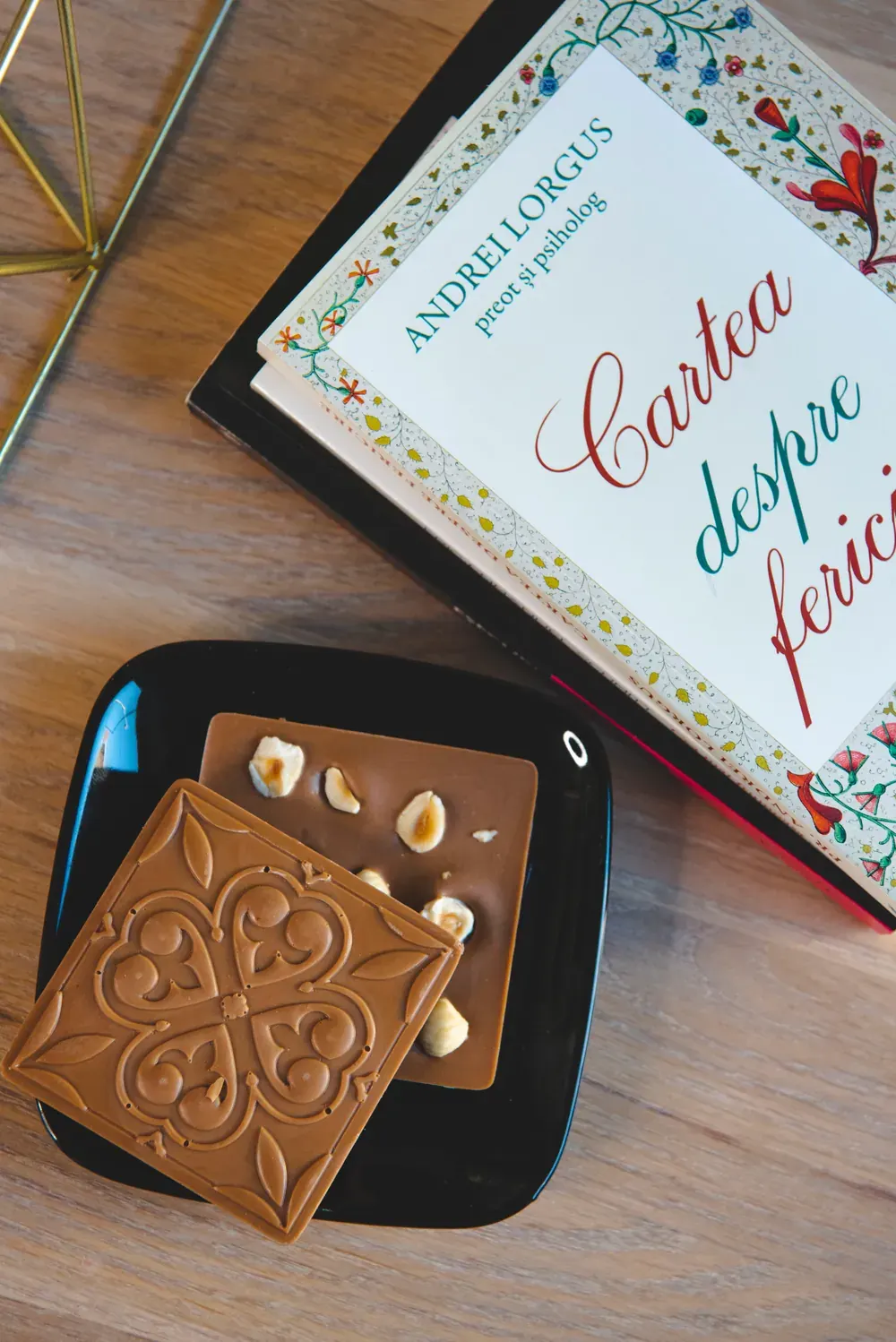 Tablete de ciocolată cu lapte și caramel Choco Toni, cu alune și migdale, lângă o carte